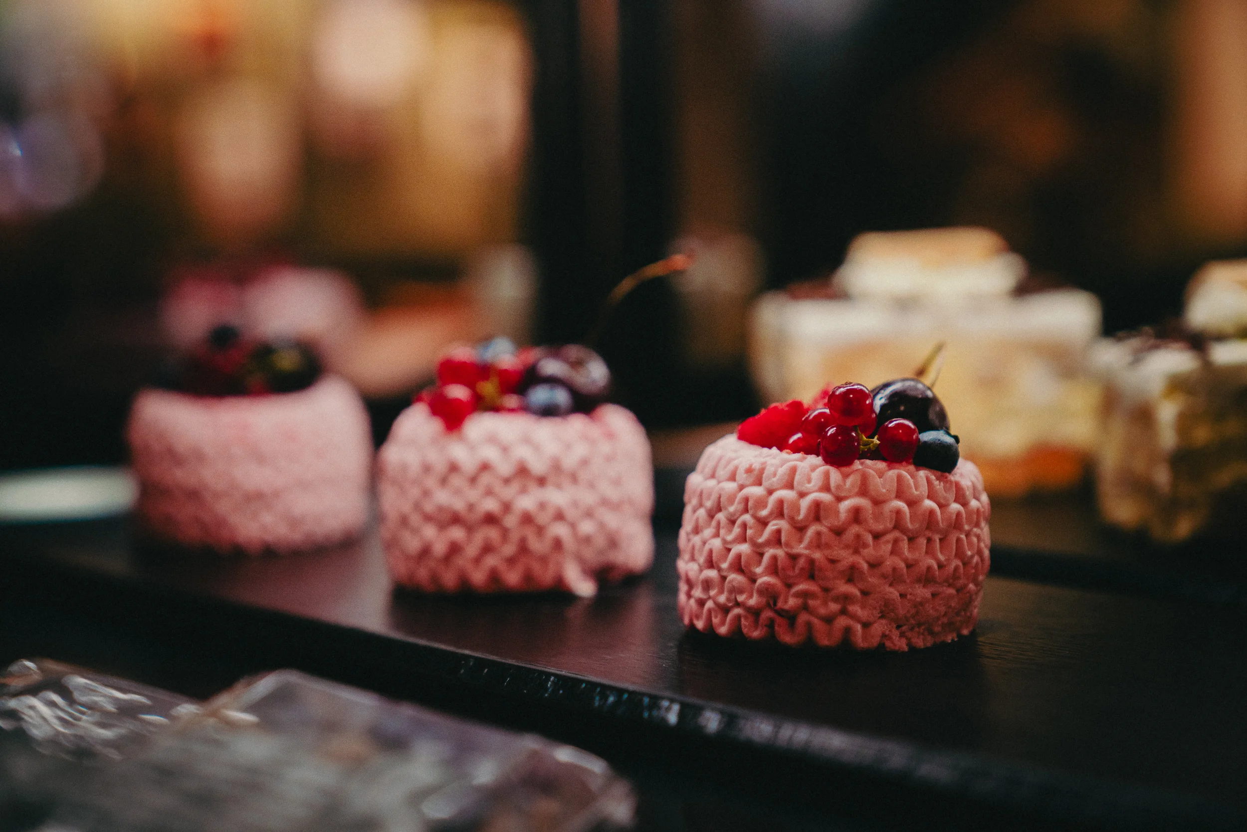 Leckere, kleine Törtchen, verziert mit verschiedenen Beeren wie Heidelbeeren und Himbeeren
