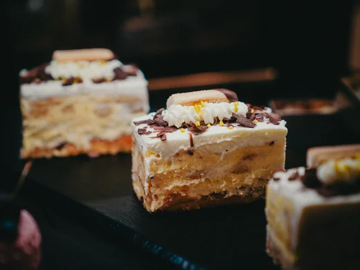 Feine Kuchenschnitten aus Mürbteig und Sahne mit Schokoraspeln verziert