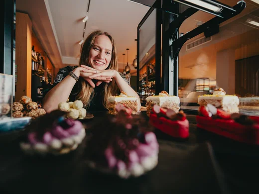 Eine kleine Auswahl an feinen Kuchenstücken und Pralinen, schön platziert auf einem Tablet