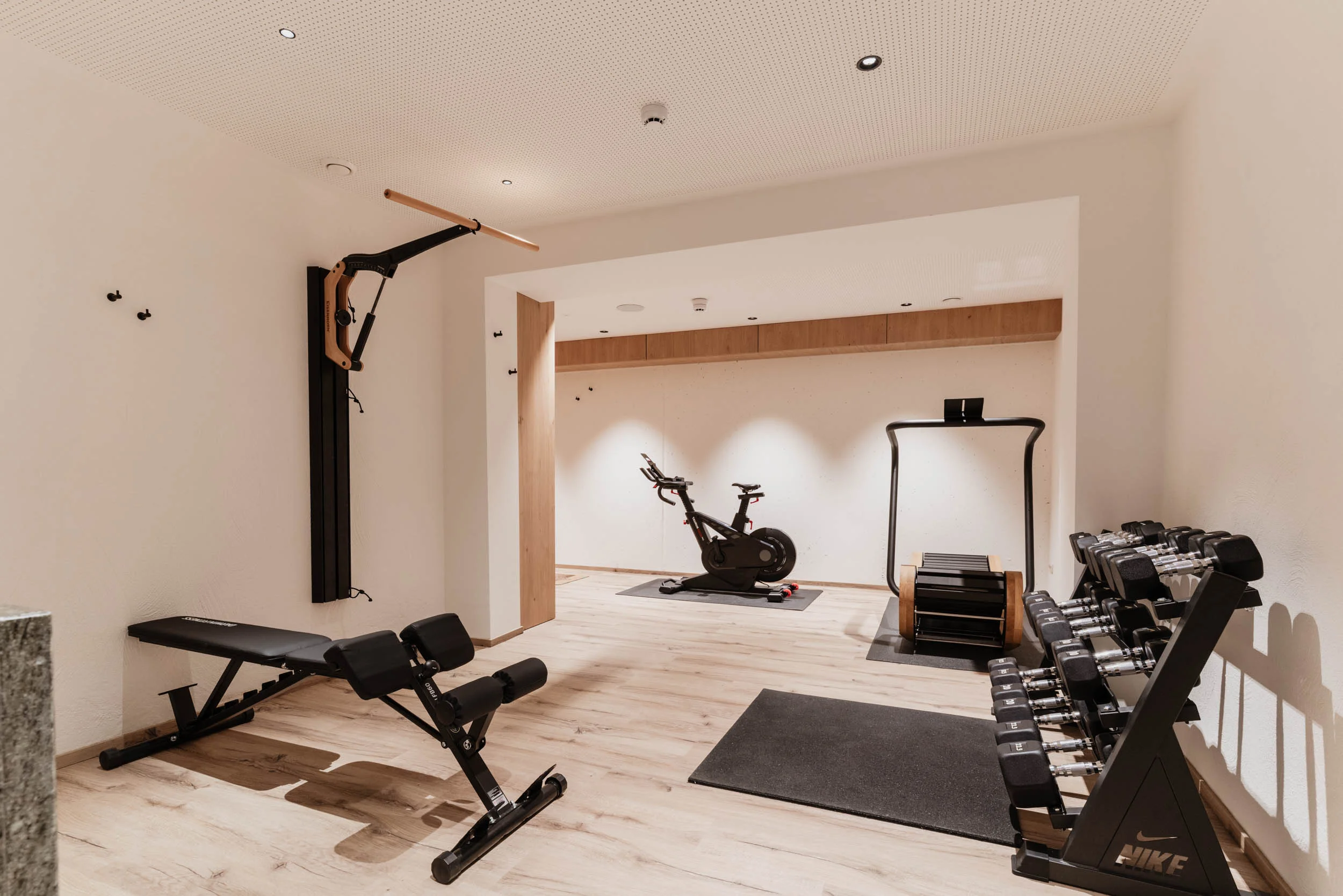 Einblick in das Fitnessstudio mit Hanteln, Fahrrad und weiteren Fitnessgeräten
