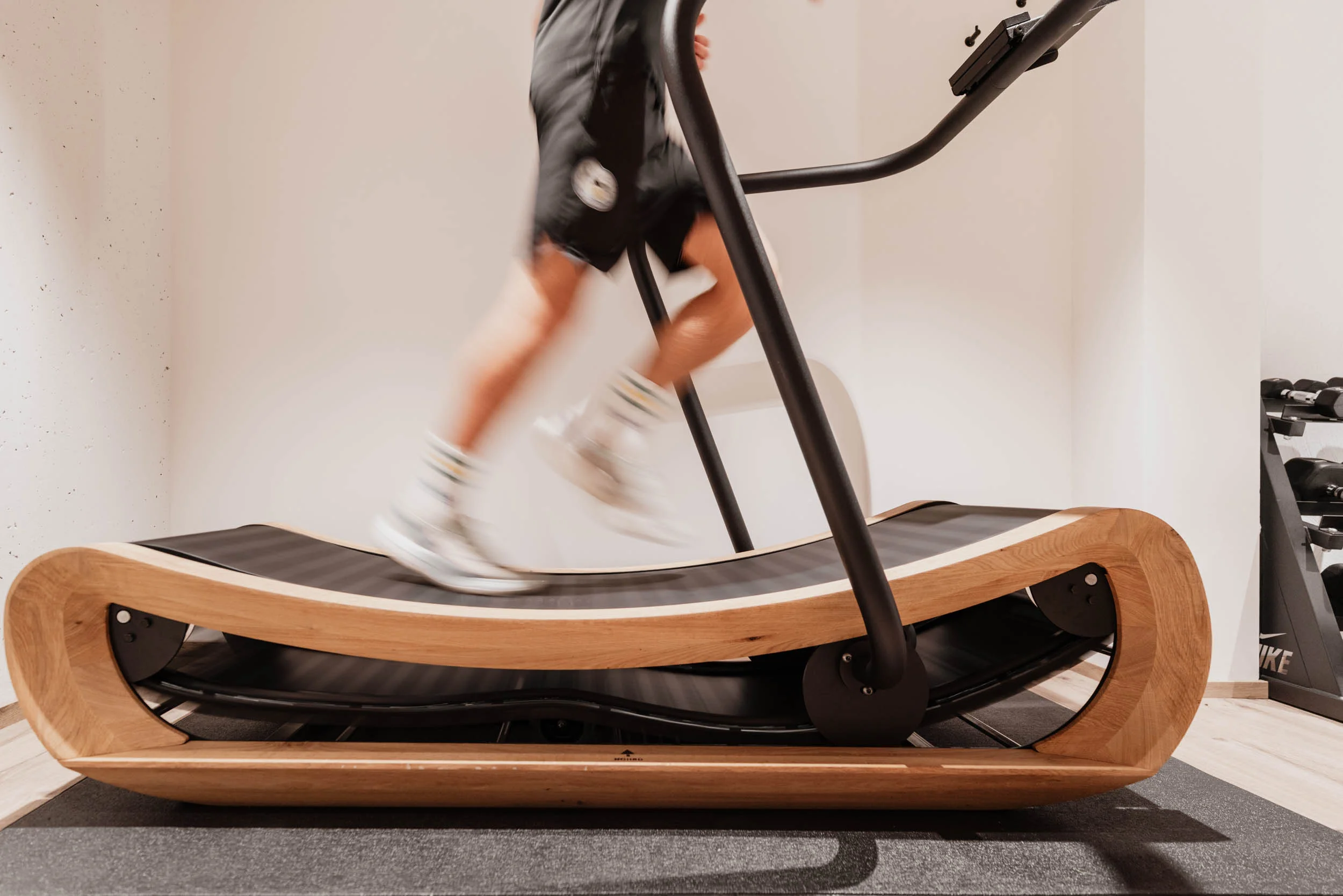 Modernes Laufband mit Holz umrandet, auf dem jemand läuft